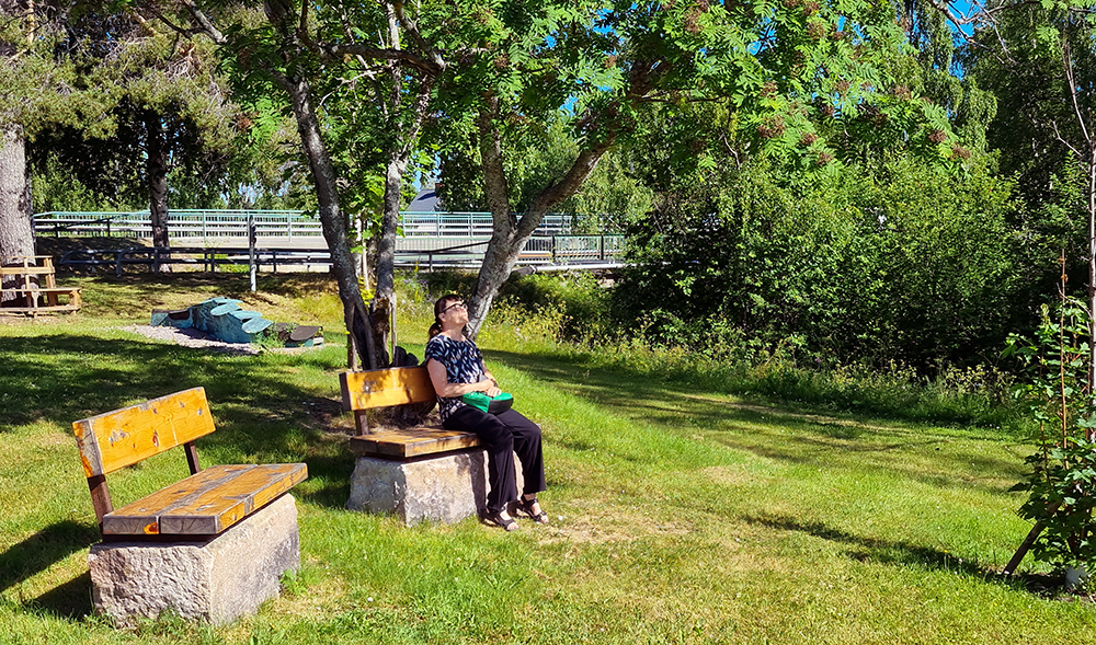 I parken finns fina sittplatser. Här hörs också bruset från älven.