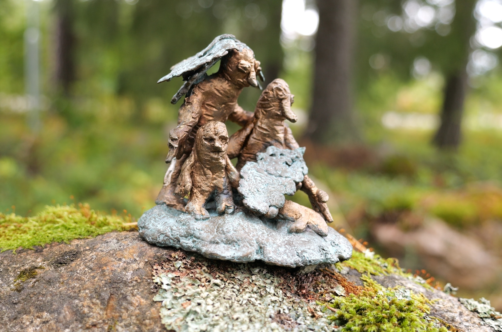 En liten bronsskulptur bestående av tre sagoväsen skulpterade efter en alunrot.